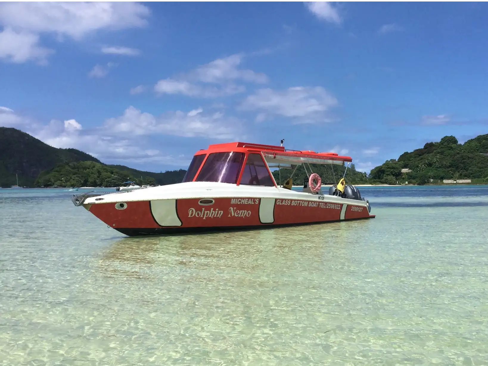 Original red-and-white Dolphin Nemo boat in clear shallow water in the Seychelles